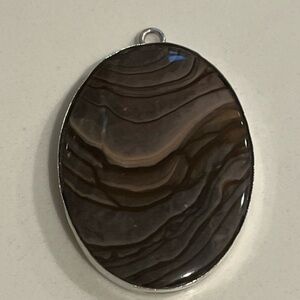 Oval-shaped large banded agate pendant, likely a Botswana Agate.